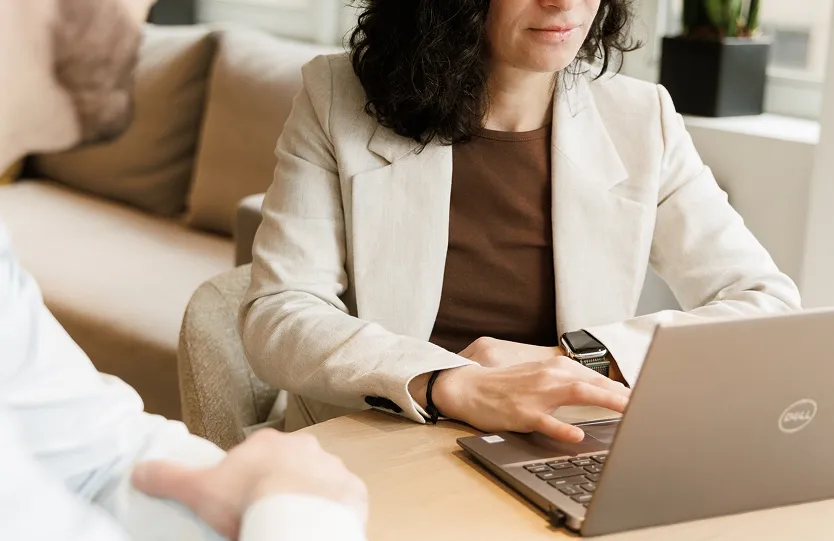 Lina Stillman in her office looking at her laptop with her client
